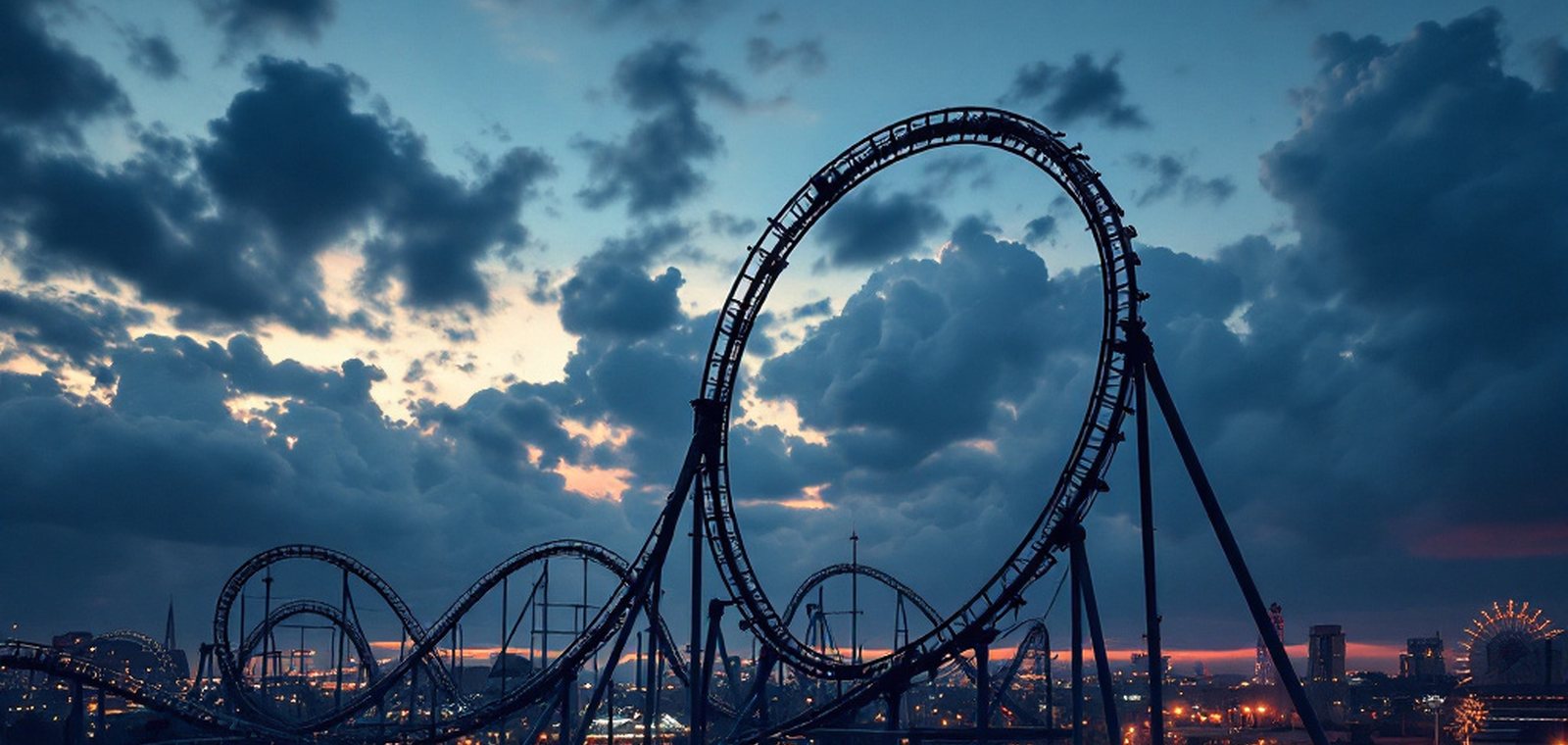 A steel roller coaster mid-loop against a dusk sky